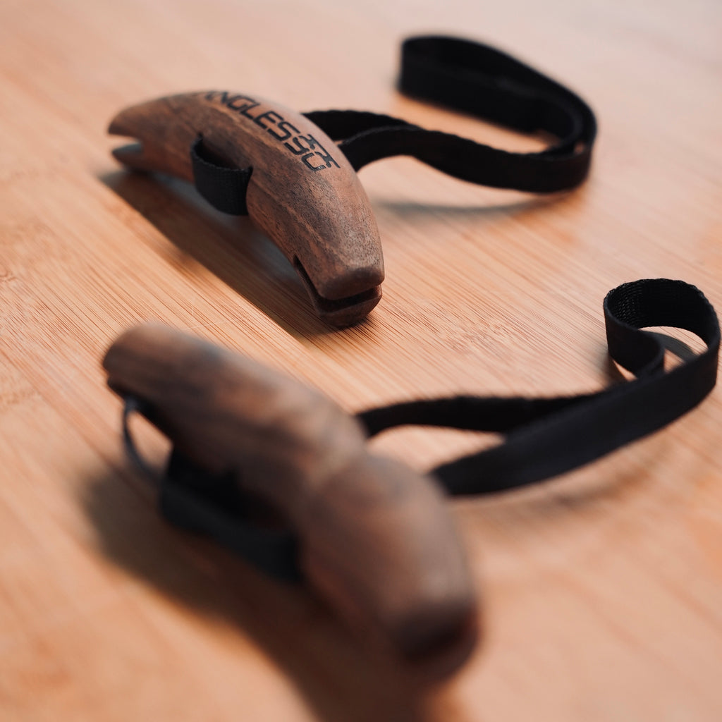 Two Angles90 Wood (Limited Edition) slingshots lying on a wooden surface, with focus on the one in the foreground, invoking a sense of nostalgia and playful adventures.